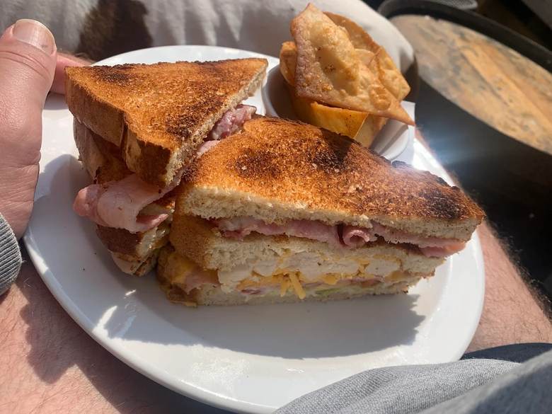 Tiny Tavern club sandwich cut in half, served with tortilla chips