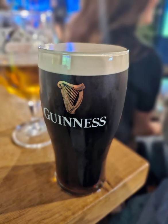 A freshly poured pint of Guinness on a wooden table
